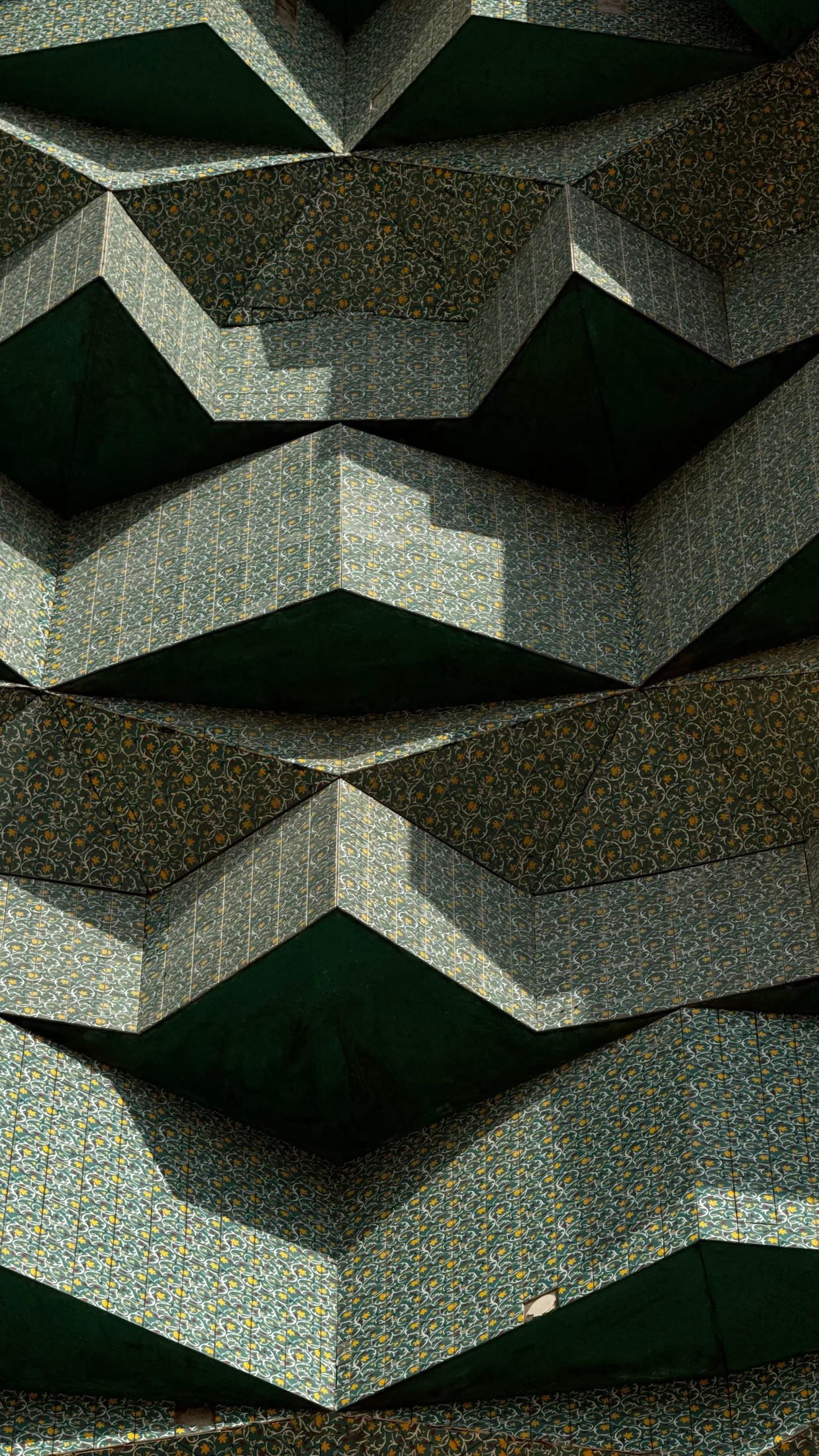 Folded green panels repeating across a wall.