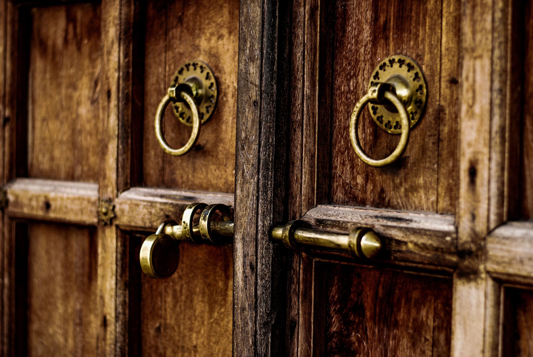 Heavy wooden doors with brass ring handles.