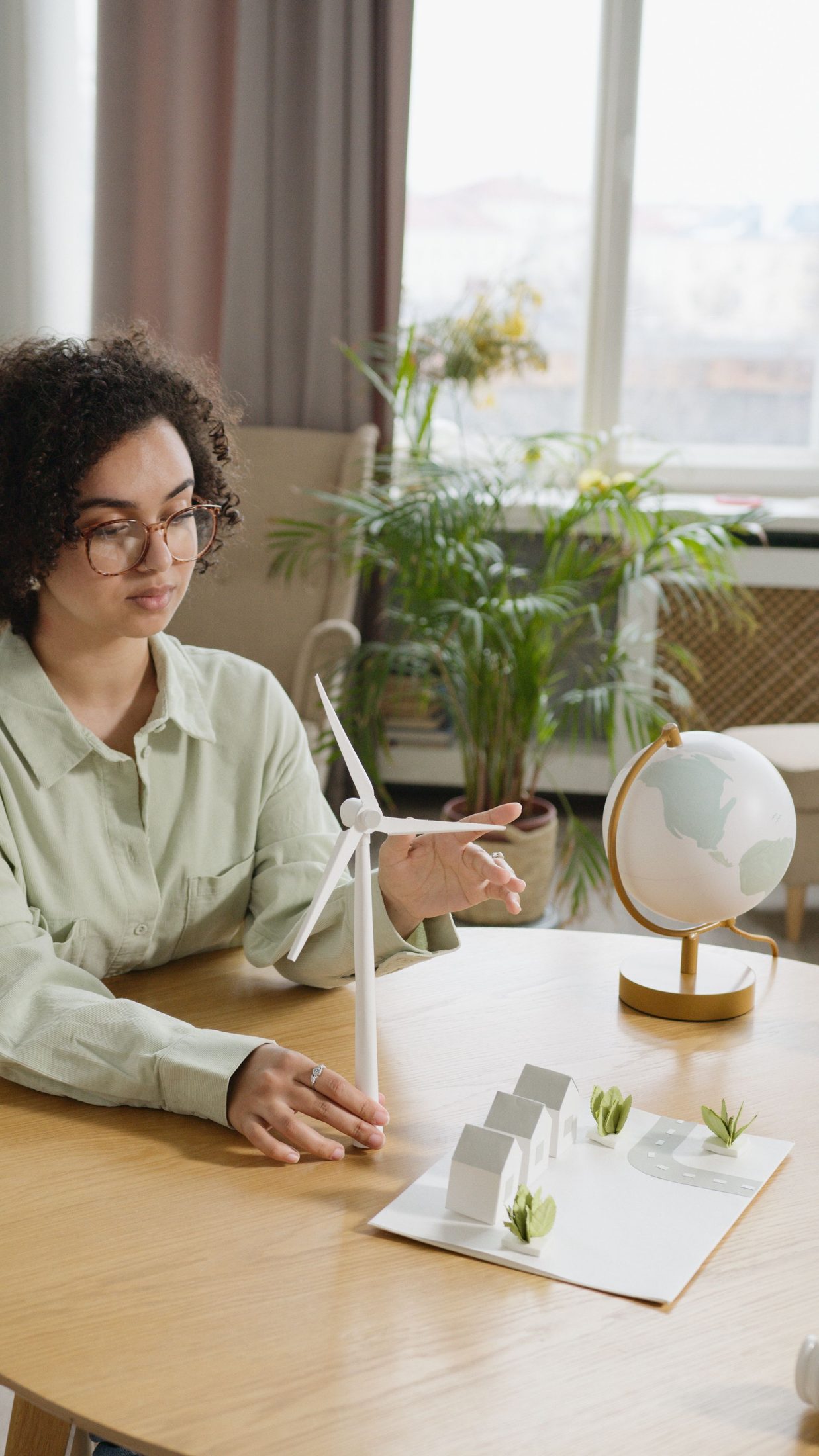 A person working through notes at a sunlit desk.